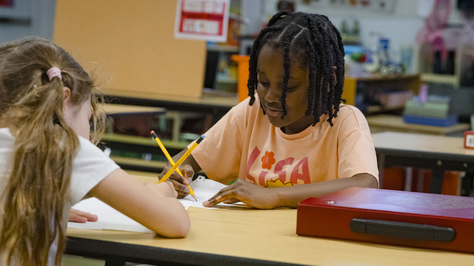 two school-aged female students doing homework in the PA Day camp